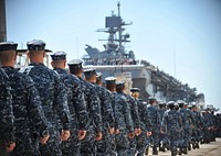 U.S. Sailors and Marines assigned to the amphibious assault ship Pre-Commissioning Unit America (LHA 6) march to the ship at the Huntington Ingalls Industries pier in Pascagoula, Miss., April 10, 2014.