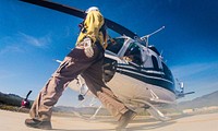 Idaho Helicopters, Inc., Assistant Chief Pilot JT Theis keeps the Bell 205A-1 helicopter steady, while a spotter performs a walk-around inspection before take off at the U.S. Department of Agriculture (USDA U.S. Forest Service (USFS) National Helicopter Rappel Program’s Rappel Academy at Salmon Air Base in Salmon, ID on Wednesday, May 14, 2014. From May 12, 2014, 72 veteran rappellers from all over the nation, 30 support staff, and three helicopters with flight crews attend the training at Salmon Air Base. Participants will rappel into the Perreau Creek area. The annual training is delivered in accordance with the National Rappel Operations Guide; strengthen leadership, teamwork, and communications within the rappel community, and produces quality aerial delivered firefighters for use in fire and aviation operations. The USDA Forest Service National Helicopter Rappel Program’s primary mission is initial attack. Rappel crews may be utilized for large fire support, all hazard incident operations, and resource management objectives.USDA Photo by Lance Cheung. Original public domain image from Flickr