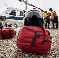 A veteran wildland firefighter rappeller's helmet and gear bag stand ready as crews practice checking each other's equipment and rappel gear before boarding a Bell 205 helicopter at the U.S. Department of Agriculture (USDA) U.S. Forest Service (USFS) National Helicopter Rappel Program’s Rappel Academy at Salmon Air Base in Salmon, ID on Tuesday, May 13, 2014.