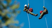 Veteran wildland firefighter rappellers use various techniques to negotiate the wind from the helicopter rotor blades above them, and away from tree branches, beside and below, as they perform a controlled and safe rappel at the U.S. Department of Agriculture (USDA) U.S. Forest Service (USFS) National Helicopter Rappel Program’s Rappel Academy at Salmon Air Base in Salmon, ID on Thursday, May 15, 2014.