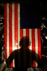 U.S. Marine Corps Corporal Jacob Hall, a crew chief with Marine Aerial Refueling Transportation Squadron 352, stands in front of an American Flag after a battlefield illumination mission aboard Camp Bastion, Afghanistan, July 18, 2014.