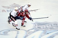 Washington’s Troy Brouwer, center, gets squeezed out of a puck chase by Chicago’s Marian Hossa, front, and Brandon Saad during the 2015 Winter Classic at Nationals Park in Washington D.C. Jan. 1, 2015.