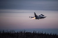 One of 14 U.S. Air Force F-16 Fighting Falcon aircraft with the 18th Aggressor Squadron takes off from Eielson Air Force Base, Alaska, shortly after sunrise Jan. 17, 2015, in transit to Joint Base Pearl Harbor-Hickam, Hawaii, and Andersen Air Force Base, Guam, to participate in the Sentry Aloha and Cope North exercises.