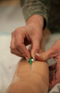 U.S. Air Force Technical Sergeant Tamera Hall, an Independent Duty Medical Technician (IDMT), draws simulated blood from an artificial arm during the biannual Nursing Skills Fair at the Landstuhl Regional Medical Center, Germany on Mar. 31, 2015.