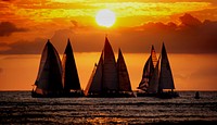 Saling into the sunset. Waikīkī is a beachfront neighborhood of Honolulu, on the south shore of the island of Oʻahu, in Hawaii, United States. Waikiki is best known for Waikīkī Beach, the white sand beach shoreline fronting the neighborhood. Original public domain image from Flickr