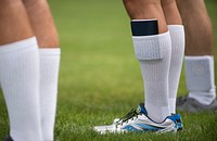 A notebook in a long sock of a man wearing sneakers. Original public domain image from Flickr