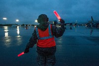 A 108th Wing Airman marshalls a departing KC-135 Stratotanker at Joint Base McGuire-Dix-Lakehurst, N.J., June 2, 2015. Original public domain image from Flickr