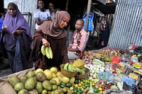 A woman buys fruits at Hamarwayne market in Mogadishu as muslims prepare for the fasting month of Ramadan, the holiest month in the Islamic calendar, June 16, 2015.AMISOM Photo/Omar Abdisalan. Original public domain image from Flickr