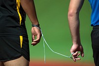 A shoelace serves as a tether between a visually impaired runner and his lane guide at the 2015 Department of Defense Warrior Games at Marine Corps Base Quantico, Va. June 28, 2015.  Original public domain image from <a href="https://www.flickr.com/photos/dodnewsfeatures/19052770380/" target="_blank">Flickr</a>