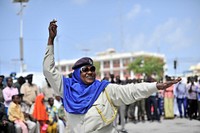 A Somali female police officer dances during the Eid Al-Fitr celebrations at the Sayidka square in Mogadishu on July 17 2015. AMISOM Photo / Ilyas Ahmed. Original public domain image from Flickr