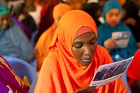 A girl reads a community policing poster during a town hall meeting at the Shibis district headquarters jointly organised by the AMISOM Police Component, the Somalia Police Force and District Administrators in Mogadishu, Somalia, on August 6, 2015. Original public domain image from Flickr