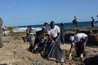 Staff of the United Nations in Somalia collect garbage during a clean-up exercise of the seashore in Mogadishu, Somalia. The exercise was part of activities to mark the 70th anniversary of the UN on October 24, 2015. UN Photo/ Omar Abdisalan. Original public domain image from Flickr