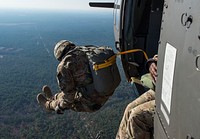 A U.S. Army Soldier jumps out of a UH-60 Black Hawk during the 18th Annual Randy Oler Memorial Operation Toy Drop, hosted by U.S. Army Civil Affairs & Psychological Operations Command (Airborne) at Camp Mackall, N.C., Dec. 8, 2015.