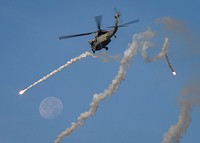 A U.S. Navy MH-60S Sea Hawk helicopter, assigned to the Indians of Helicopter Sea Combat Squadron (HSC) 6, fires celebratory flares during a change of command ceremony in the Arabian Gulf Dec. 6, 2017.