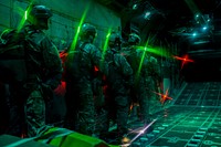 U.S. Air Force (AF) Survival Evasion Resistance Escape (SERE) specialists wait before preforming static line jumps as the door of a C-130, assigned to Dobbins Air Reserve Base, opens over the Nevada Test and Training Range, March 11, 2016.