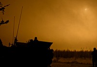 U.S. Army Soldiers, the Iron Troop, with 3rd Squadron, 2nd Cavalry Regiment, stationed out of Vilseck, Germany, watch from an M1129 Mortar Carrier Vehicle as an illuminating round lights up the battle field at night during a live fire exercise at Tapa Training Area, Estonia, Mar. 8-11, 2016.