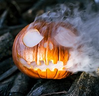 Carved Halloween pumpkin with smoke. Free public domain CC0 photo.