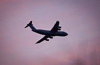 A U.S. Air Force C-5 Galaxy from the 436th Airlift Wing flies over New Jersey while lit by the setting sun.