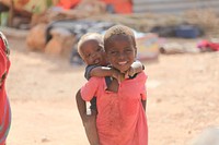 Two children affected by recent flooding in the Hiraan region of Somalia can be seen in a temporary camp set up near the town of Beletweyne, Somalia, on May 25, 2016. The current floods have already displaced over 17,000 people and are the worst floods to hit the area since 1981. UN Photo. Original public domain image from Flickr