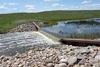 A water control structure regulates flow on a Wetlands Reserve Program project in Hill County, Montana. June 1, 2011. Original public domain image from Flickr