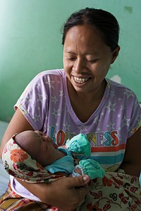 Woman holding baby. Kelahiran Bayi yang Sehat Menjadi Harapan Semua Ibu. Every mother expects to have a healthy baby. USAID EMAS works to do just that. Photo courtesy of USAID EMAS. Original public domain image from Flickr