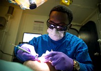 MEDITERRANEAN SEA (July 18, 2016) Hospitalman Andre Parrish cleans the teeth of a patient aboard the amphibious assault ship USS Wasp (LHD 1) July 18, 2016.