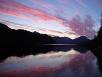 After three days of clear skies, some light clouds rolled in just as the sun was setting in Hasselborg Lake, Admiralty Island National Monument, Tongass National Forest, Alaska. (Forest Service photo by Matthew Thompson). Original public domain image from Flickr