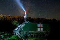 U.S. Army Pfc. Dylan Scott, a combat medic with Headquarters and Headquarters Company, 3rd Battalion, 116th Cavalry Brigade Combat Team out of Pendleton, Oregon, watches the night sky on top of an M113 Medical Evacuation Vehicle during Exercise Saber Guardian 16 at the Romanian Land Forces Combat Training Center in Cincu, Romania.