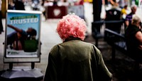 Pink haired lady walking in a city, rear view. Original public domain image from Flickr