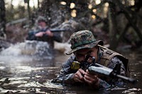 U.S. Marine Corps Cpl. Tanner Casares, a production specialist with the Combat Camera section, Marine Corps Combat Service Support Schools, navigates through a water obstacle while conducting an obstacle course on Camp Johnson, N.C., December 12, 2016.