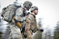 A soldier assigned to Comanche Company, 1st Battalion, 501st Parachute Infantry Regiment, 4th Infantry Brigade Combat Team (Airborne), 25th Infantry Division, U.S. Army Alaska, encourages a fellow paratrooper during a 12-mile tactical foot march on Joint Base Elmendorf-Richardson, Alaska, April 27, 2017. Foot marches are the movement of troops and equipment, mainly by foot, with limited support by vehicles. They are characterized by combat readiness, ease of control, adaptability to terrain, slow rate of movement, and increased personnel fatigue. (U.S. Air Force photo/Justin Connaher). Original public domain image from Flickr