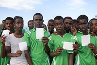 Somalia youth hold white cards as symbols of peace, at a ceremony to mark International Sports Day for development and peace in Mogadishu on April 06, 2017. UN Photo / Ilyas Ahmed. Original public domain image from Flickr