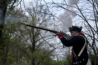 An American Revolution Continental Army reenactor fires a musket officially starting the 12-mile ruck march during the Region 1 Competition Best Warrior Competition at Washington Crossing State Park, Titusville, N.J., April 26, 2017. Fourteen U.S. Army National Guard Soldiers and noncommissioned officers from the six New England states, New Jersey, and New York are competing in the three-day event, April 25-27, 2017, which features timed events, including urban warfare simulations, land navigation, and the Army Physical Fitness Test. The two winners will go on to compete in the 2017 Army National Guard Best Warrior Competition to be named the Army Guard's best-of-the-best and earn the title of the Soldier and Noncommissioned Officer of the Year. The Best Warrior Competition recognizes Soldiers who demonstrate commitment to the Army values, embody the Warrior Ethos, and represent the Force of the Future. (U.S. Air National Guard photo by Master Sgt. Matt Hecht /Released). Original public domain image from Flickr