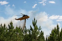 Helicopter supports fire operation on West Mims Fire. Original public domain image from <a href="https://www.flickr.com/photos/usfwssoutheast/34254536932/" target="_blank">Flickr</a>