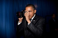 President Barack Obama takes aim with a photographer's camera backstage prior to remarks about providing mortgage payment relief for responsible homeowners at Dobson High School, Mesa, Ariz., Feb. 18, 2009.