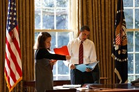 President Barack Obama looks at daily correspondence with his personal secretary Katie Johnson in the Oval Office, Jan. 30, 2009.