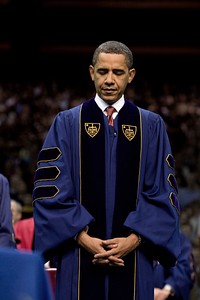 President Barack Obama bows his head during the invocation at the University of Notre Dame's commencement ceremony, May 17, 2009.