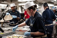 MEDITERRANEAN SEA (July 15, 2017) Chief Electronics Technician Kayla Jaramillo puts toppings on her handmade pizza in the chiefs mess aboard the aircraft carrier USS George H.W. Bush (CVN 77).