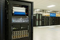 Liquidcool solutions team members install "liquid submerged server" at the energy systems integration facility's high performance computing data center at National Renewable Energy Laboratory. Original public domain image from Flickr