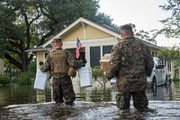 U.S. Marine Corps Sgt. Ben Tomerlin, left, a platoon sergeant, and Marine Gunnery Sgt. Jose Montoya, right, a utilities chief with the 14th Marine Regiment, 4th Marine Division, Marine Forces Reserves, walk supplies through a flooded street in Orange, Texas , Sept. 3, 2017.