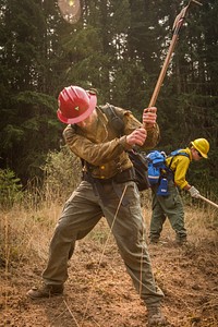 Zane Willert, a firefighter with the Devil's Canyon Handcrew, demonstrates how to dig a handline while supervising tactical training with the Soldiers assigned to 23rd Brigade Engineer Battalion, 1-2 Stryker Brigade Combat Team, Umpqua North Complex, Oregon, September 8, 2017.