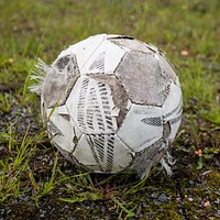 Closeup on old football in grass. Free public domain CC0 photo.