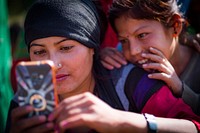 Woman and girl using phone in Kailash, Bajhang District, Nepal, October 2017.