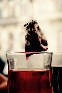 Teabag hanging above tea cup. Free public domain CC0 image