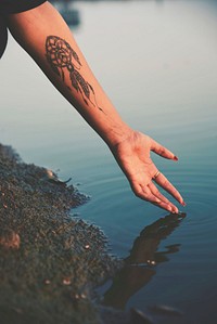 Free close up tattoo on arm with water image, public domain person CC0 photo.
