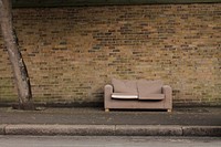 Sofa in public, brick wall. Free public domain CC0 photo.