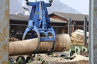 Crane picking up tree trunk during construction. Free public domain CC0 photo.