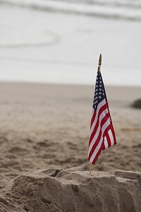 American flag on beach sand. Free public domain CC0 photo.