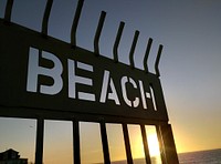 Beach sign silhouette during sunset. Free public domain CC0 photo.