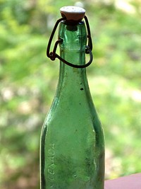 Empy green glass bottle with a cap. Free public domain CC0 image